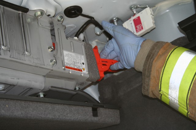 A Firefighter Removes A Plug Or Circuit Breaker That Will Make The Car Safer for Firefighters to Work