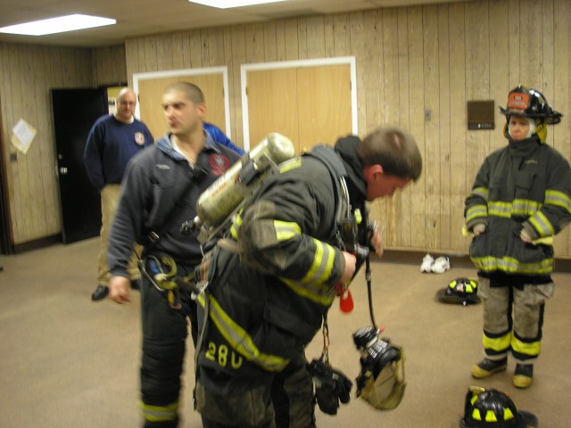 Firefighter Gurdineer Shows The New Firefighters How To Put On An Airpack While Captain Cerrato Explains Each Step