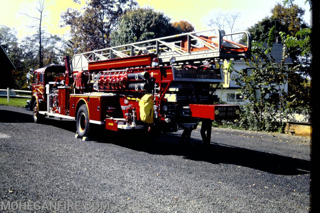 October 1969. Rear view of Quad 10 showing various ground ladders and hoses. Notice the helmets on the side of the apparatus as all gear used to be carried on the apparatus. Photo by Jim Forbes